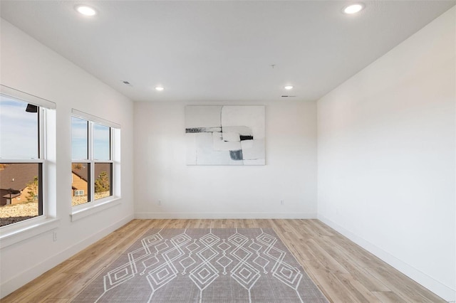 unfurnished room with light wood finished floors, recessed lighting, and baseboards