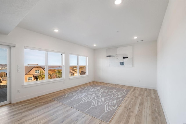 unfurnished room with recessed lighting, light wood-type flooring, and baseboards