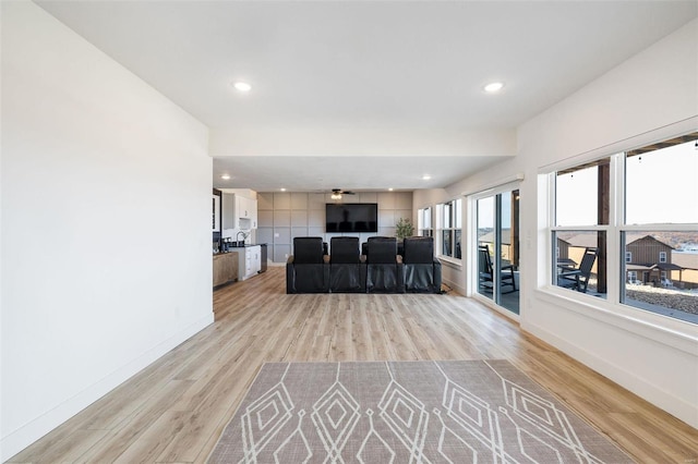 living area with recessed lighting, light wood-style flooring, and baseboards