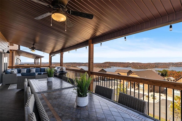 wooden deck with outdoor lounge area and a ceiling fan