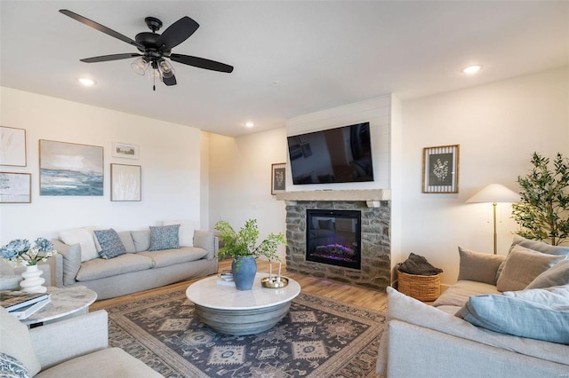 living room with ceiling fan, recessed lighting, a fireplace, and wood finished floors