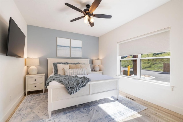 bedroom featuring light wood finished floors, ceiling fan, and baseboards