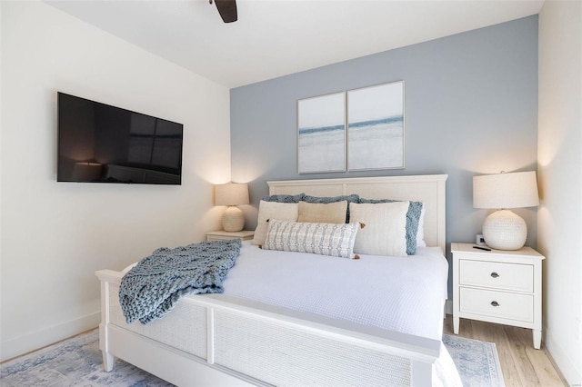 bedroom with light wood-style floors, ceiling fan, and baseboards