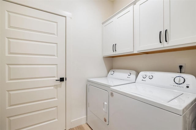 washroom featuring light wood-type flooring, cabinet space, independent washer and dryer, and baseboards