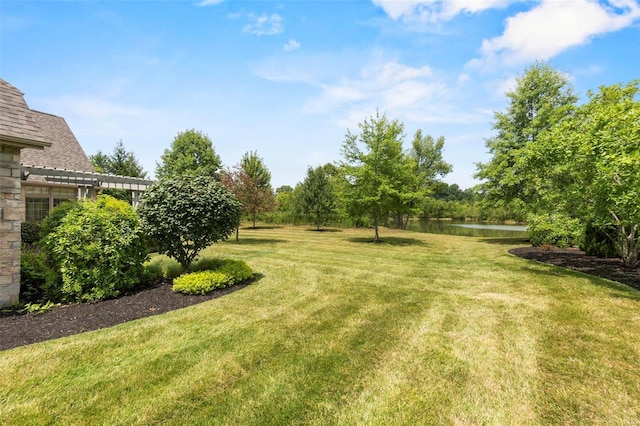 view of yard with a pergola and a water view