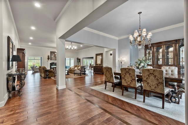 dining space featuring crown molding, an inviting chandelier, and dark hardwood / wood-style flooring