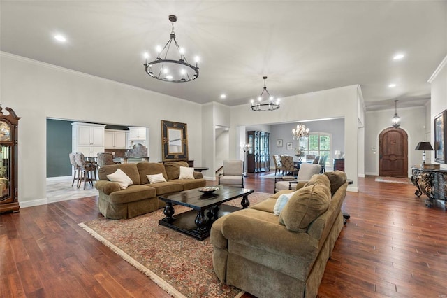 living room with a chandelier, dark wood-type flooring, and ornamental molding