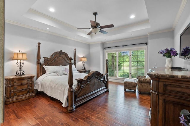 bedroom featuring crown molding, dark wood-type flooring, ceiling fan, and a tray ceiling