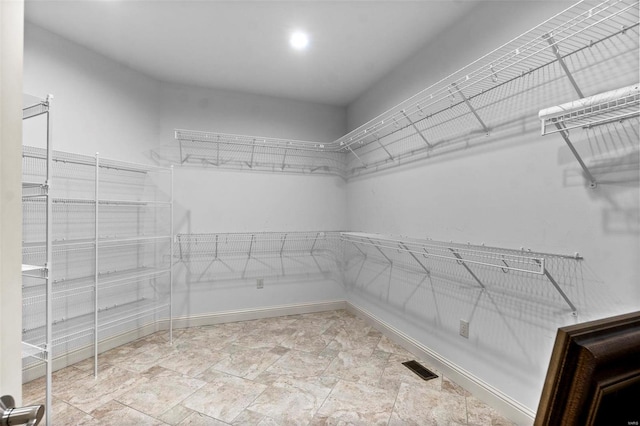 walk in closet featuring light tile floors