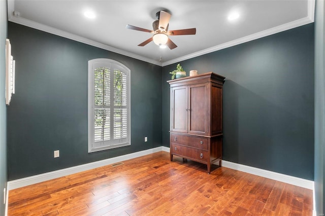 empty room featuring hardwood / wood-style floors, crown molding, and ceiling fan