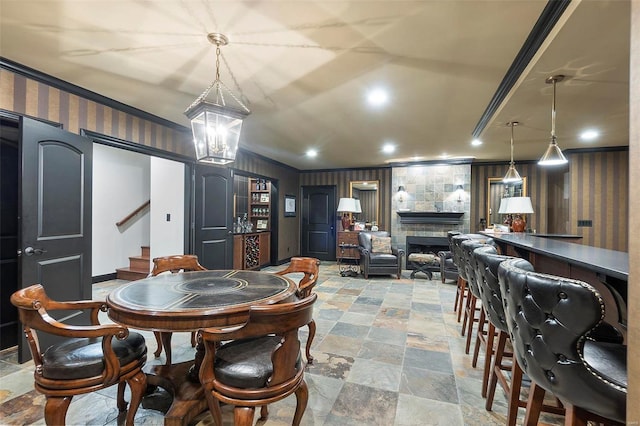 tiled dining room with a stone fireplace