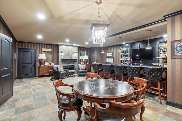 tiled dining area featuring bar and a fireplace