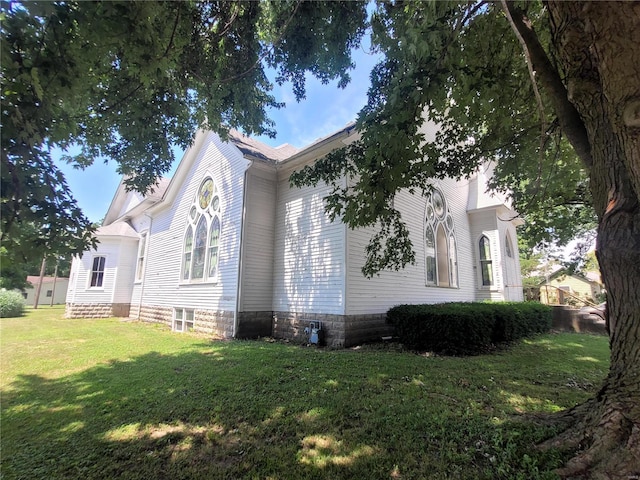 view of side of home with a yard