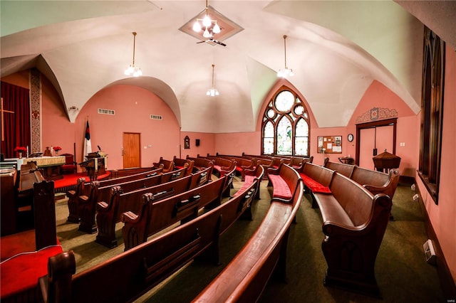 carpeted cinema room with high vaulted ceiling