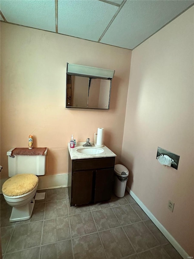 bathroom with toilet, tile flooring, and vanity