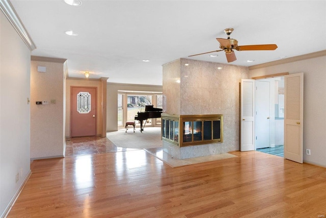 unfurnished living room with a multi sided fireplace, crown molding, and light hardwood / wood-style flooring