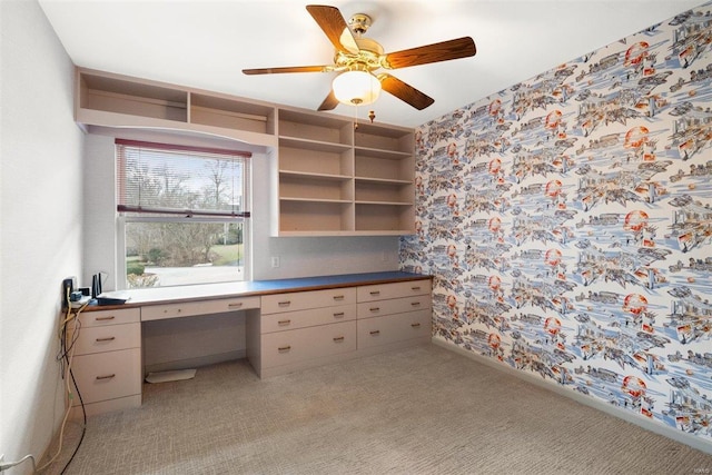 carpeted home office featuring ceiling fan and built in desk