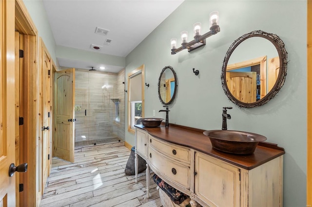 bathroom featuring hardwood / wood-style flooring, vanity, and an enclosed shower