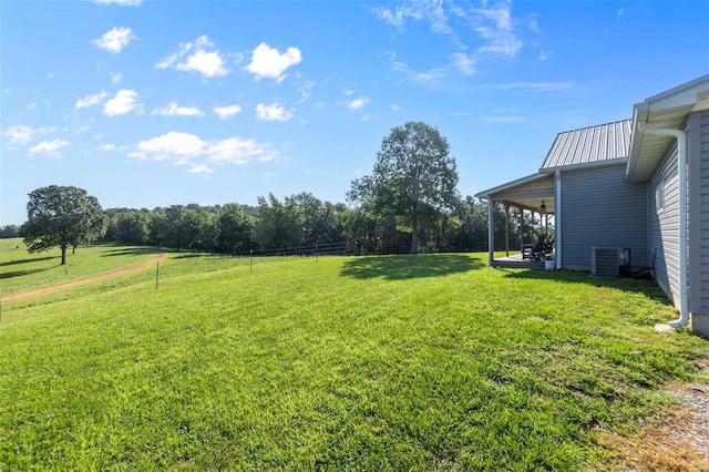 view of yard with central AC and a rural view