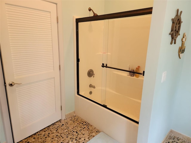 bathroom featuring shower / bath combination with glass door and tile floors