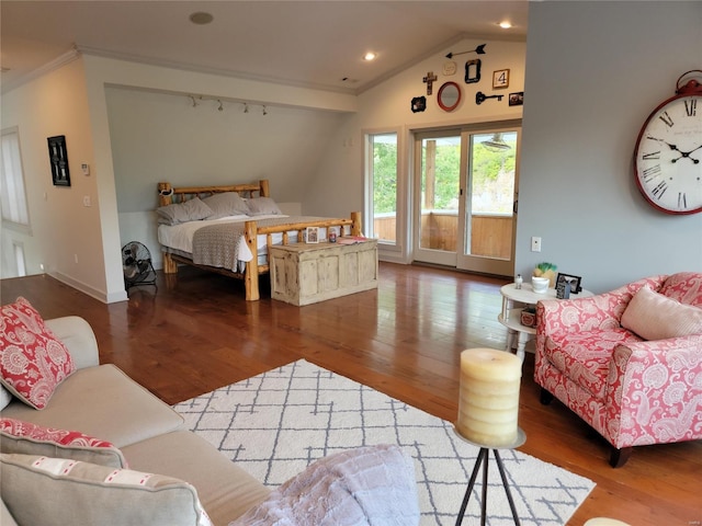 bedroom with access to outside, rail lighting, wood-type flooring, and vaulted ceiling