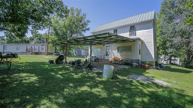 back of property with a carport and a yard