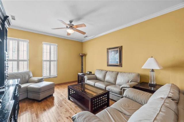 living room with light hardwood / wood-style floors, ornamental molding, and ceiling fan