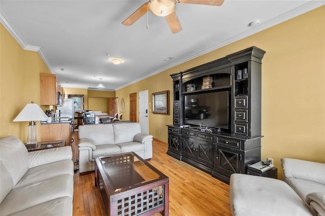 living room with ornamental molding, light hardwood / wood-style floors, and ceiling fan