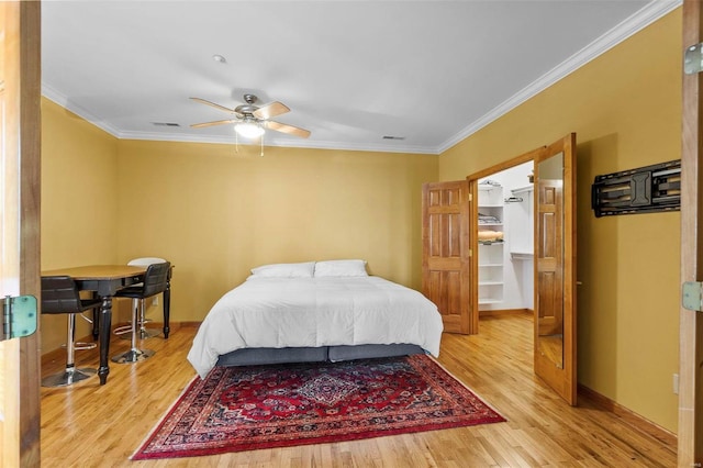 bedroom with ceiling fan, ornamental molding, and light hardwood / wood-style floors