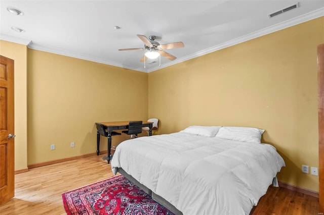 bedroom with ceiling fan, crown molding, and light hardwood / wood-style floors