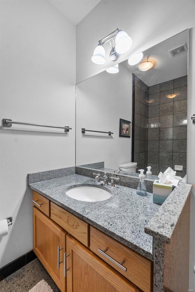 bathroom featuring toilet, tile floors, and vanity