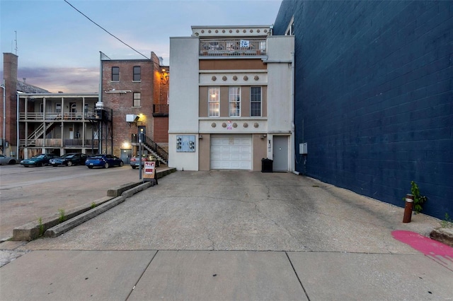 view of front of property featuring a balcony and a garage