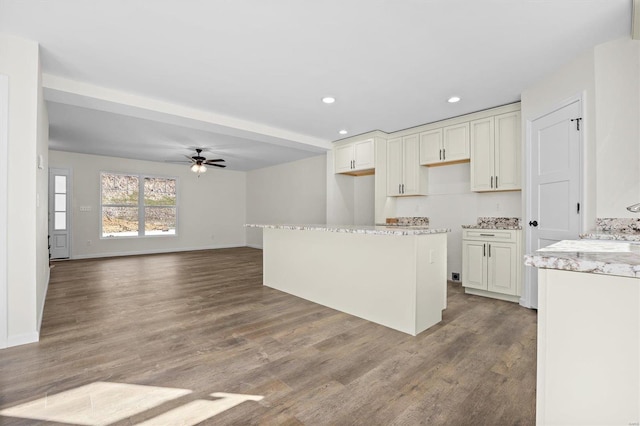 kitchen with hardwood / wood-style floors, white cabinetry, and ceiling fan