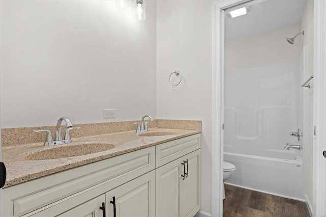 full bathroom with double sink vanity, shower / bath combination, hardwood / wood-style flooring, and toilet