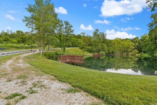 view of property's community with a lawn and a water view