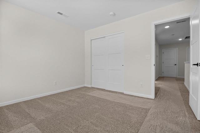 unfurnished bedroom featuring carpet, baseboards, visible vents, and a closet