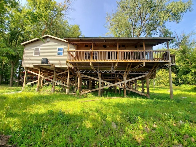 back of house featuring a wooden deck and a lawn