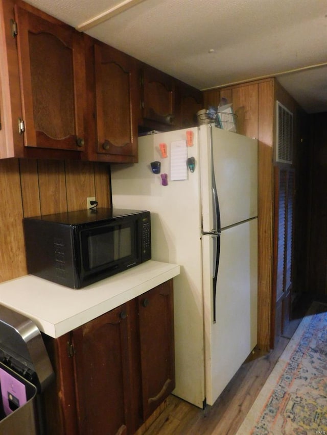 kitchen with white refrigerator and wood-type flooring