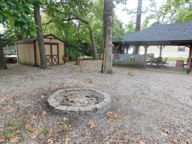 view of yard featuring a patio area, an outdoor fire pit, and a storage shed