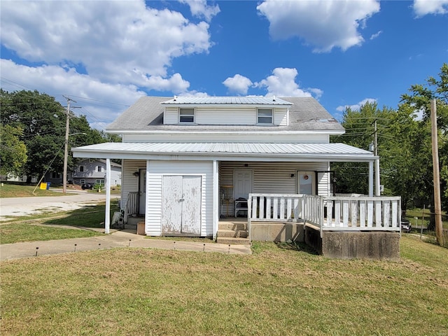 rear view of house featuring a lawn and a porch