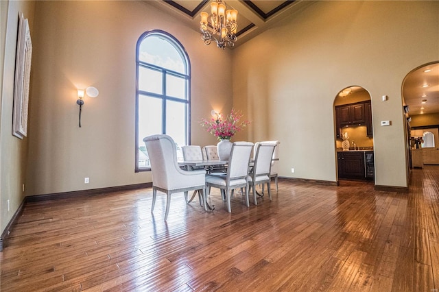 dining area with a towering ceiling and dark hardwood / wood-style floors