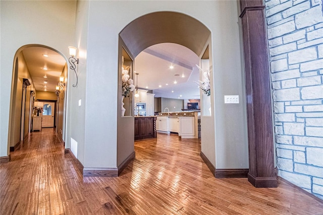 hallway with sink and light wood-type flooring