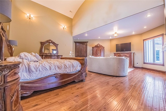 bedroom with high vaulted ceiling and light hardwood / wood-style flooring