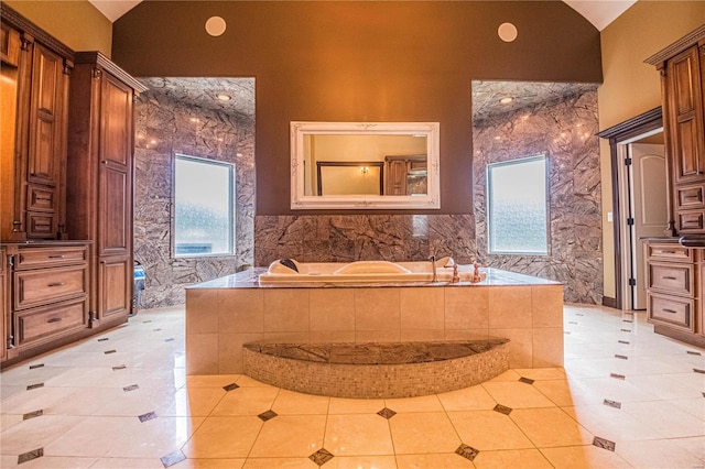 bathroom with tiled bath, plenty of natural light, tile flooring, and a towering ceiling