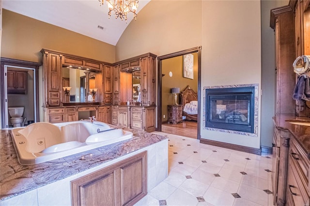 bathroom with toilet, high vaulted ceiling, a notable chandelier, vanity, and hardwood / wood-style floors