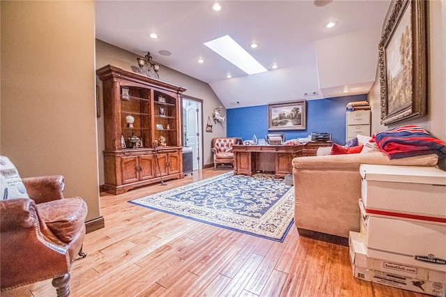 living room with lofted ceiling with skylight and light hardwood / wood-style flooring