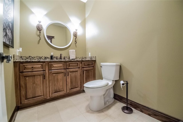 bathroom featuring toilet, vanity, and tile flooring