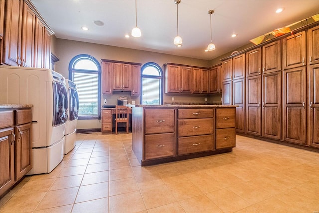 kitchen with light tile floors, washer and dryer, and pendant lighting