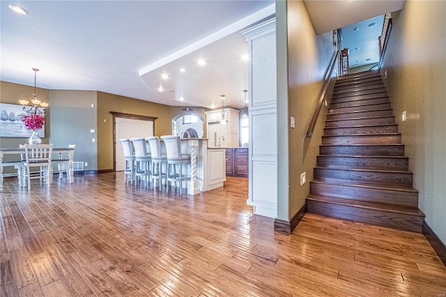 stairway featuring light wood-type flooring and a chandelier