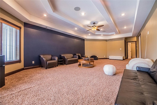 carpeted home theater with a tray ceiling and ceiling fan